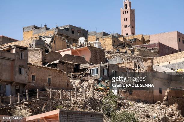 The minaret of a mosque stands behind damaged or destroyed houses following an earthquake in Moulay Brahim, Al-Haouz province, on September 9, 2023....