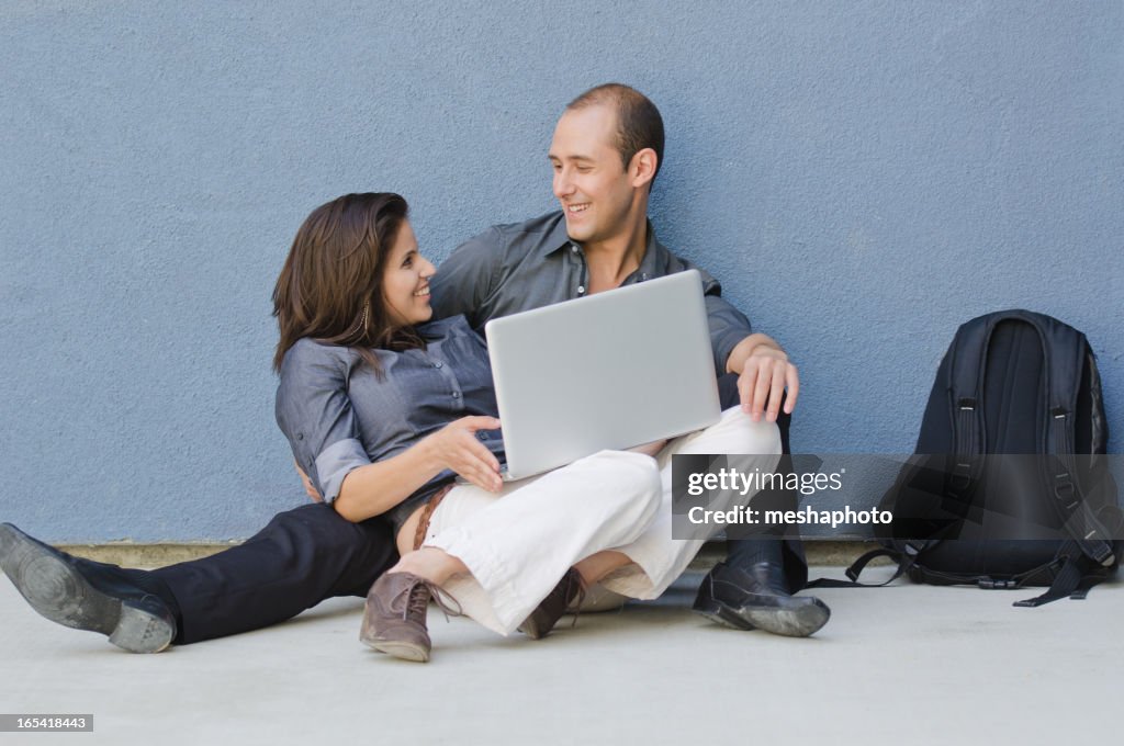 Joven pareja feliz con la computadora portátil