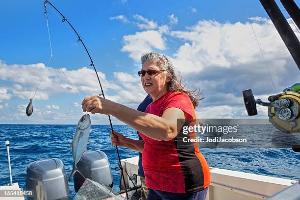 senior woman fishing - motorboot varen stockfoto's en -beelden