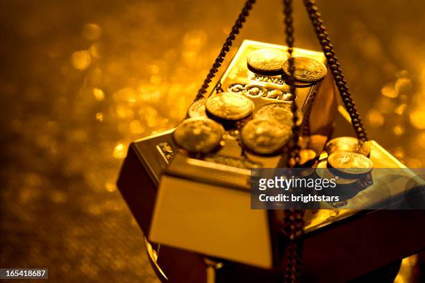 gold on weight scale - gold bullion stockfoto's en -beelden