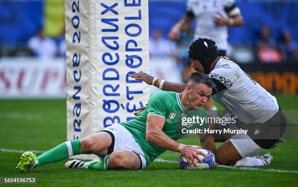 Bordeaux , France - 9 September 2023; Jonathan Sexton of Ireland scores his side's fifth try despite the tackle of Jason Tomane of Romania during the...