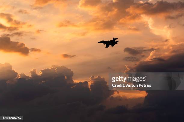 fighter aircraft in the clouds at sunset. military aviation - missile defense command stock pictures, royalty-free photos & images