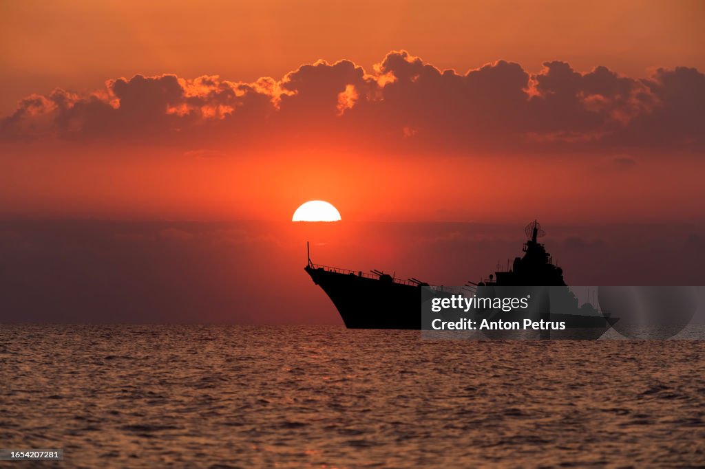 Warship at sunset in the sea. Fleet flagship