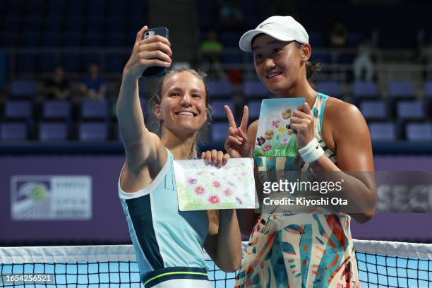 Winner Viktorija Golubic of Switzerland and runner-up Wang Xiyu of China celebrate with the trophy after the Women's Singles final match during the...