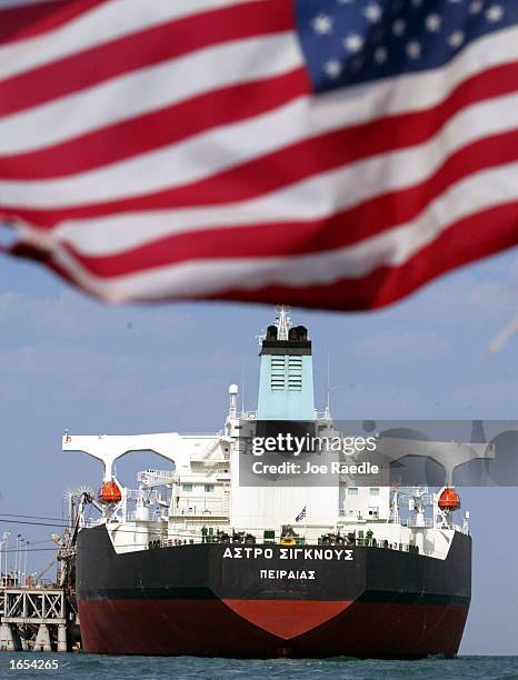 An American flag flies from a rib boat as U.S. Navy sailors from the USS Fletcher inspect an oil tanker that is being filled from an Iraqi oil...