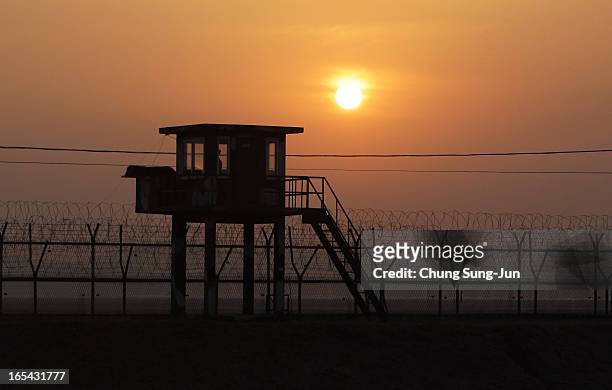 The sun sets near a barbed-wire checkpoint near the border village of Panmunjom on April 4, 2013 in Paju, South Korea. Still 400 South Korean remain...