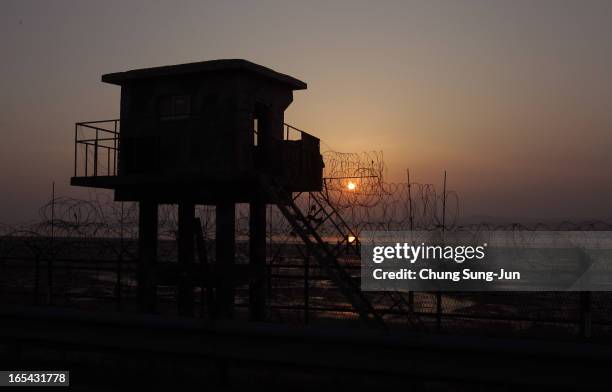 The sun sets near a barbed-wire checkpoint near the border village of Panmunjom on April 4, 2013 in Paju, South Korea. Still 400 South Korean remain...