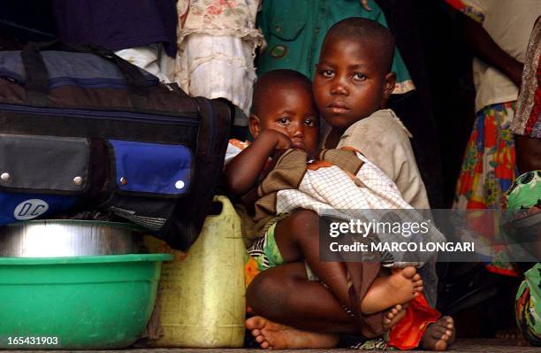 Two children take a rest 12 October 2002 near the Kanyaru river in the Burundian town of Gatumba at the border between the Democratic Republic of...