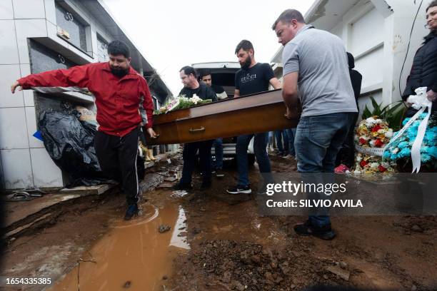 Men carry the coffin of a victim of a cyclone that hit Mucum, Rio Grande do Sul, Brazil, during his funeral in the city's cemetery, on September 9,...