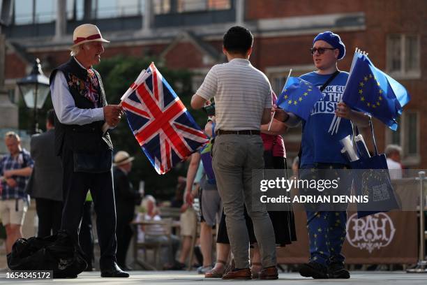 Pro-EU activist hands out EU flags beside a Union flag seller as concert-goers arrive at the Royal Albert Hall in London on September 9 for the Last...