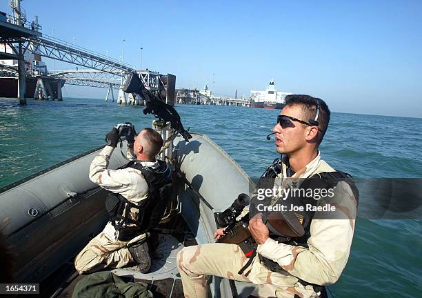 Navy sailors Dustin Beltz and Matthew Wright from the USS Fletcher ride in a rib boat as they inspect oil tankers that are being filled from an Iraqi...