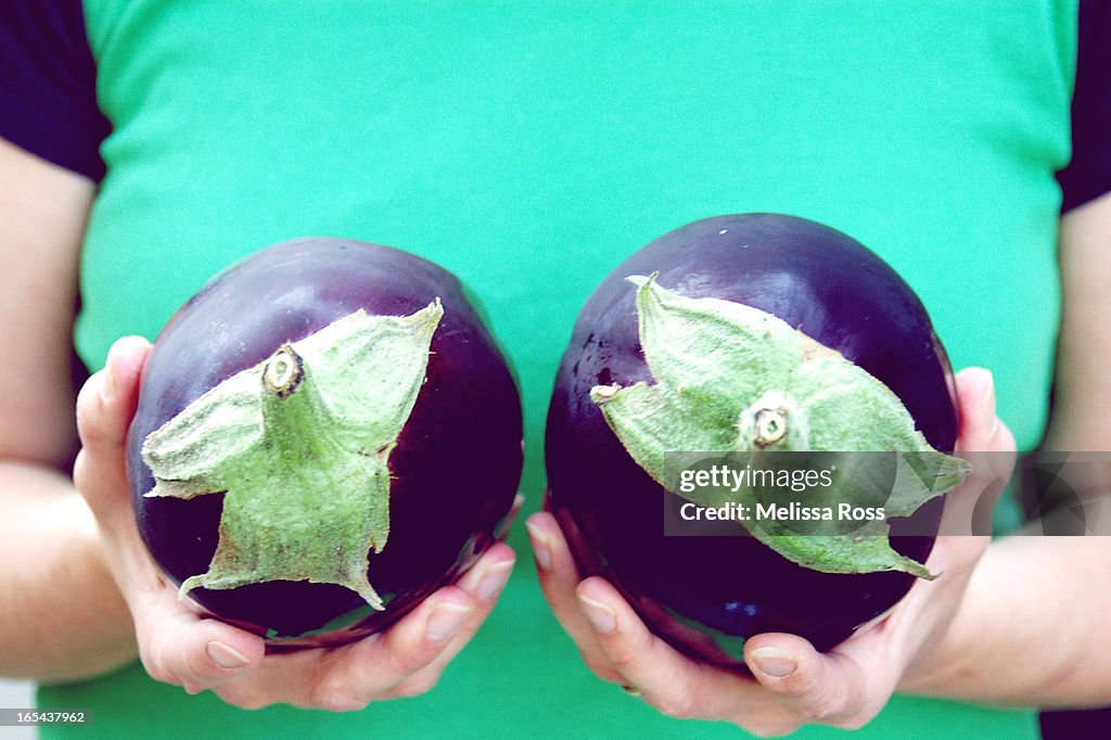 Woman holding eggplants to her chest