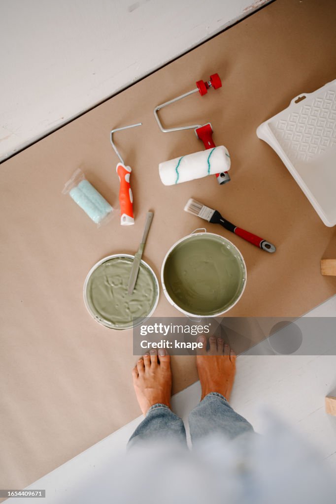 Donna che dipinge le sue pareti verde a casa