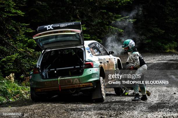Finland's Sami Pajari and her co-driver Enni Malkonen make repairs to their damaged Fabia RS at the special stage Pavliani during the Acropolis rally...