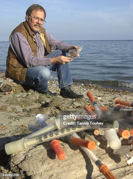 Bil Thuma looks over the 60 some odd hypodermic needles he has collected from his private beach in Etobicoke over the past 2 years. Toronto Health...