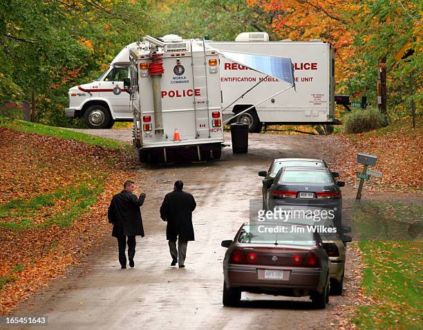 York Region police homicide detectives approach the scene on 7th Concession of King Township where a burned out SUV containing two bodies was...