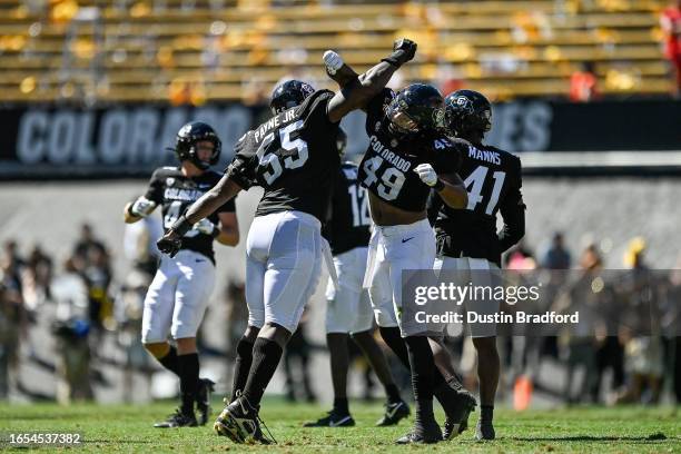 Defensive lineman Leonard Payne Jr. #55 of the Colorado Buffaloes celebrates with defensive end Taijh Alston after a second quarter sack against the...