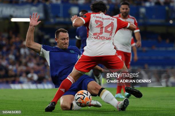 Chelsea legend John Terry tackles Bayern legend Piotr Trochowski during the Legends football match between Chelsea and Bayern Munich at Stamford...