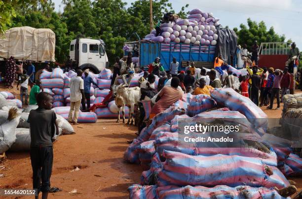 People load the trucks with cargos arrived from Benin by boats to be transported to different cities in Gaya, Niger on September 09, 2023. Following...