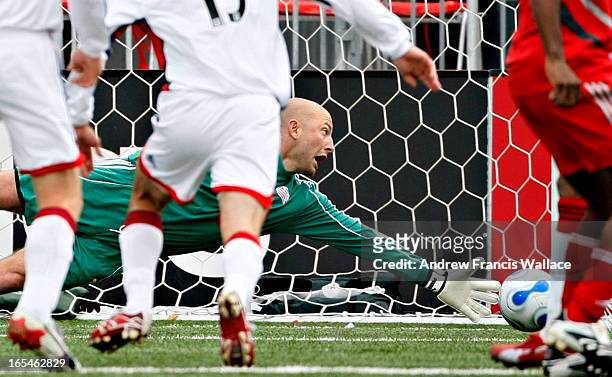 New England Revolution goalkeeper Matt Reis reaches for the ball off the post from Toronto FC Marvell Wynne during second half action at BMO Field in...