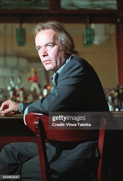 Pics of Martin Amis in The Senator Restaraunt ,portrait at bar with cig,then sitting with a line of liquor bottles behind him.