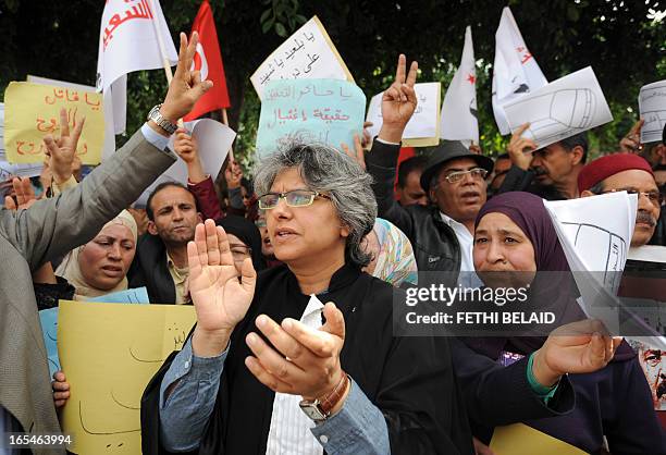 Besma Khalfaoui , the widow of slain Tunisian opposition leader Chokri Belaid, claps as she demonstrates with fellow protestors holding banners in...