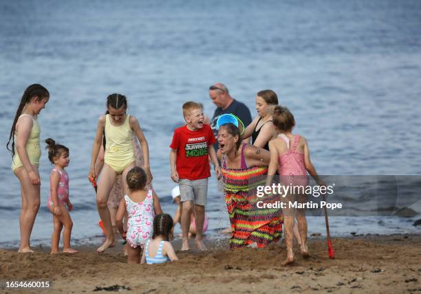 Sunbather has water poured over her head by the sea on September 9, 2023 in South Shields, England. The UK is experiencing a late summer heatwave as...