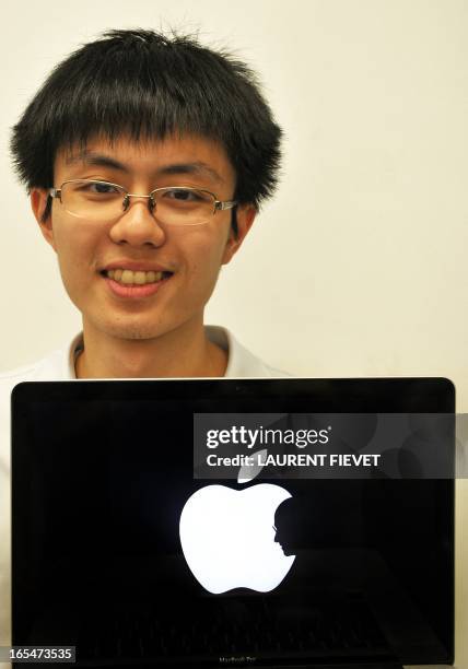 Jonathan Mak, a student at the Polytechnic University, poses with his laptop showing his self-designed sombre logo in tribute of Apple founder Steve...