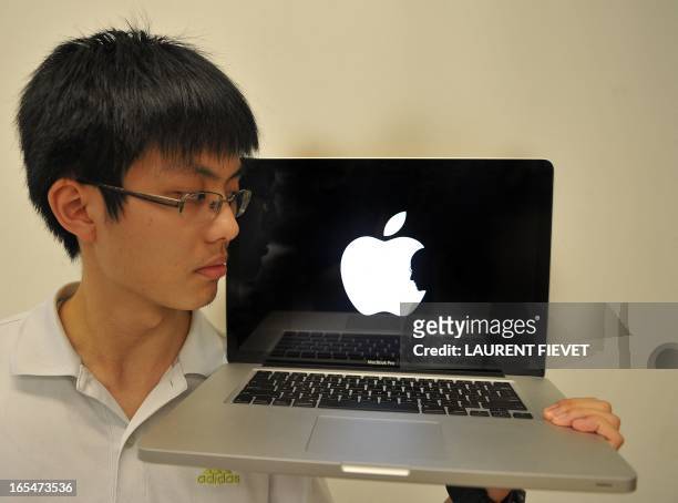 Jonathan Mak, a student at the Polytechnic University, poses with his laptop showing his self-designed sombre logo in tribute of Apple founder Steve...