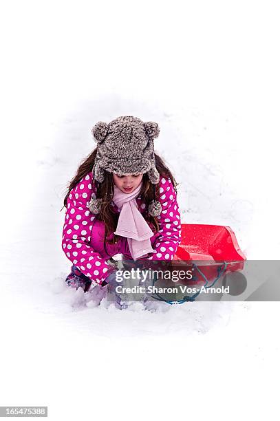 girl making snowballs, holding sledge - making snowball stock pictures, royalty-free photos & images