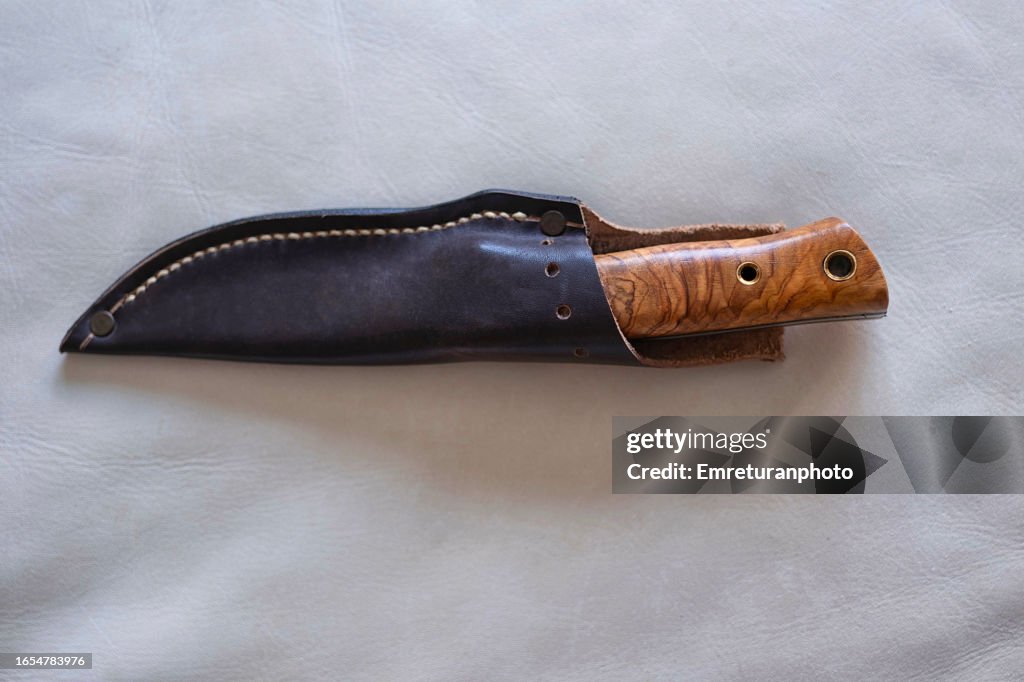 Close up of utility knife in brown leather case.