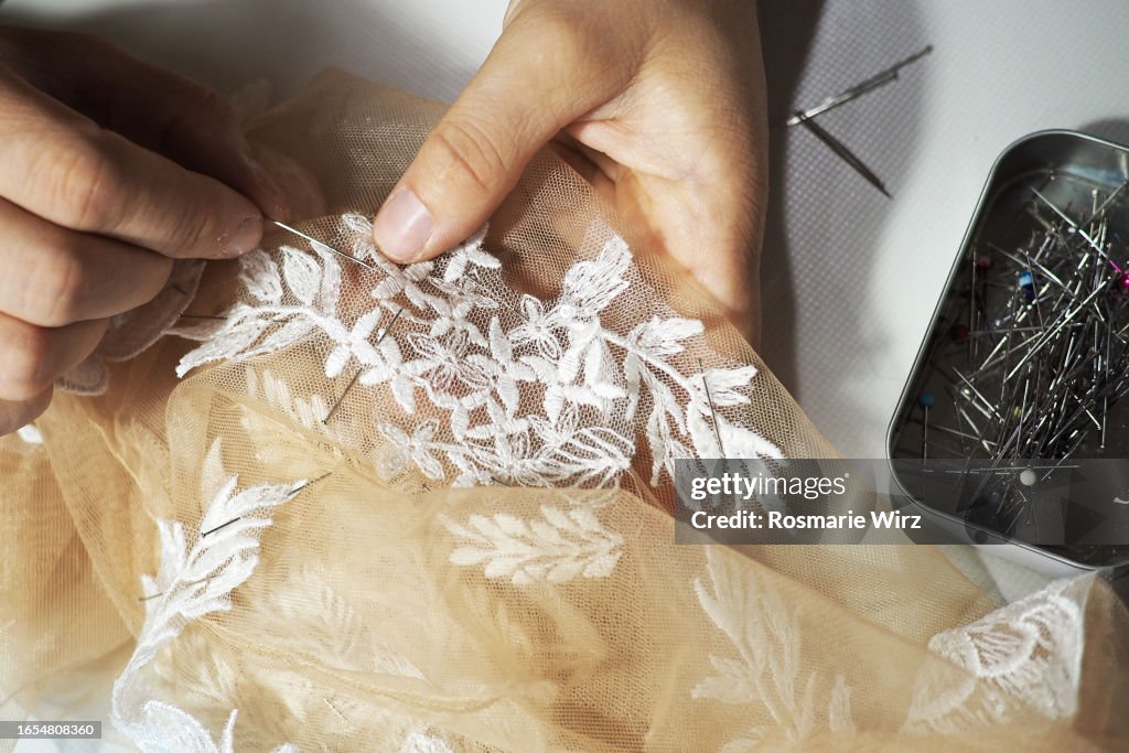 Closse-up of hands pinning lace material