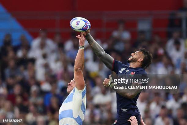 Argentina's lock Tomas Lavanini and England's blindside flanker and captain Courtney Lawes jump for the ball in a line out during the France 2023...