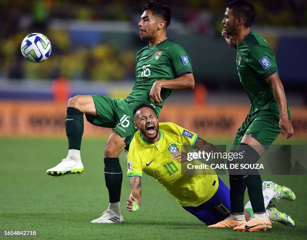 Brazil's Neymar falls as he is marked by Bolivia's midfielder Boris Cespedes and midfielder Diego Bejarano during the 2026 FIFA World Cup South...