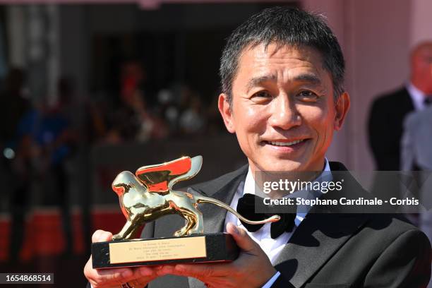 Tony Leung Chiu-wai poses on the red carpet after being awarded with the Golden Lion for Lifetime Achievement award at the 80th Venice International...