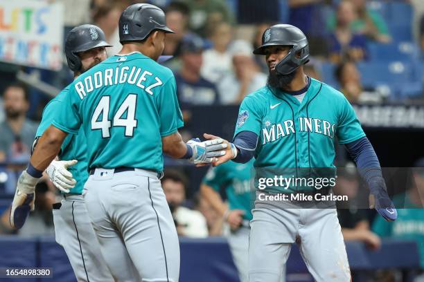 Julio Rodriguez of the Seattle Mariners celebrates with Teoscar Hernandez after both scored against the Tampa Bay Rays during the first inning of a...