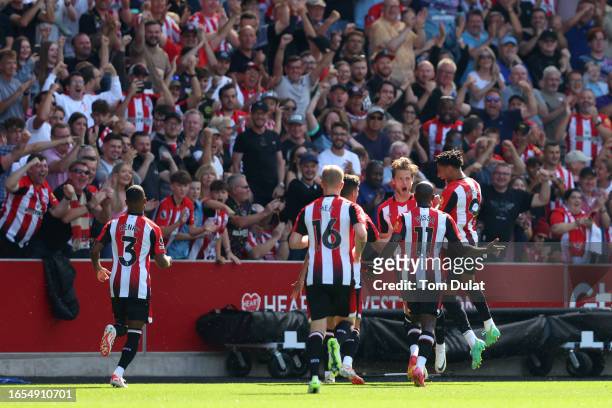 Mathias Jensen of Brentford celebrates with teammates after scoring the team's first goal during the Premier League match between Brentford FC and...