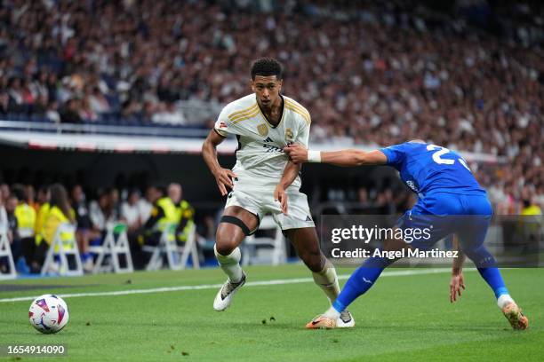 Jude Bellingham of Real Madrid is put under pressure by Stefan Mitrovic of Getafe CF during the LaLiga EA Sports match between Real Madrid CF and...