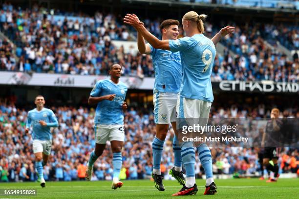 Julian Alvarez of Manchester City celebrates with teammate Erling Haaland after scoring the team's first goal during the Premier League match between...