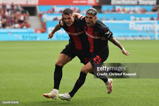 Exequiel Palacios of Bayer Leverkusen celebrates with teammate Granit Xhaka after scoring the team's second goal during the Bundesliga match between...