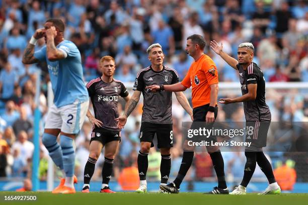 Harry Wilson and Andreas Pereira of Fulham react to Match Referee Michael Oliver after the second goal for Manchester City scored by Nathan Ake of...