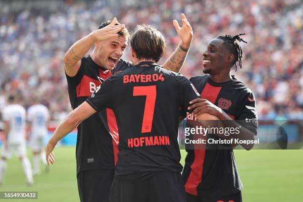 Jonas Hofmann of Bayer Leverkusen celebrates with teammates Granit Xhaka and Jeremie Frimpong after scoring the team's fourth goal during the...