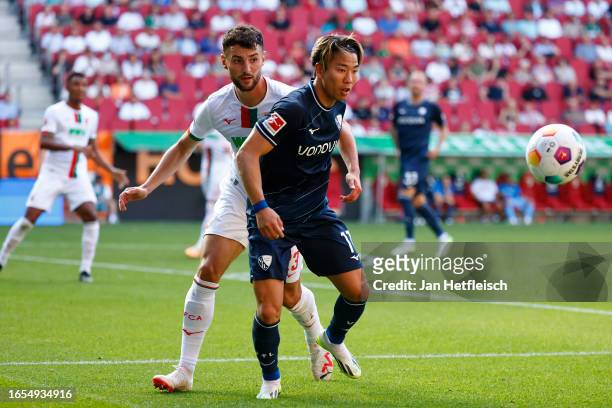 Takuma Asano of VfL Bochum battles for possession with Maximilian Bauer of FC Augsburg during the Bundesliga match between FC Augsburg and VfL Bochum...
