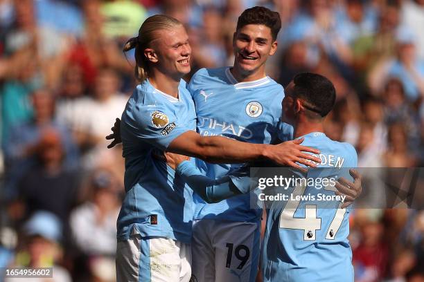 Erling Haaland of Manchester City celebrates with teammates Julian Alvarez and Phil Foden after scoring the team's third goal during the Premier...