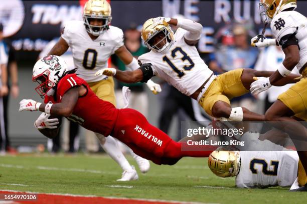 Juice Vereen of the NC State Wolfpack dives toward the end zone against Thomas Harper and DJ Brown of the Notre Dame Fighting Irish during the second...