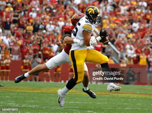 Tight end Luke Lachey Logan Lee of the Iowa Hawkeyes catches a pass as defensive back Beau Freyler of the Iowa State Cyclones defends in the first...