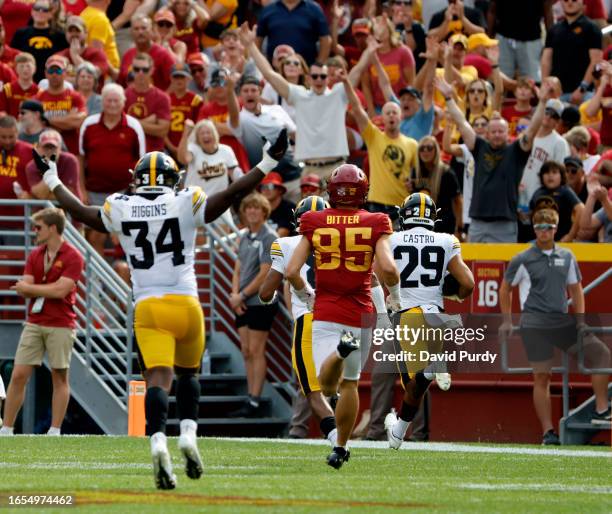 Defensive back Sebastian Castro of the Iowa Hawkeyes returns a pass interception for a touchdown down as teammate linebacker Jay Higgins celebrates...