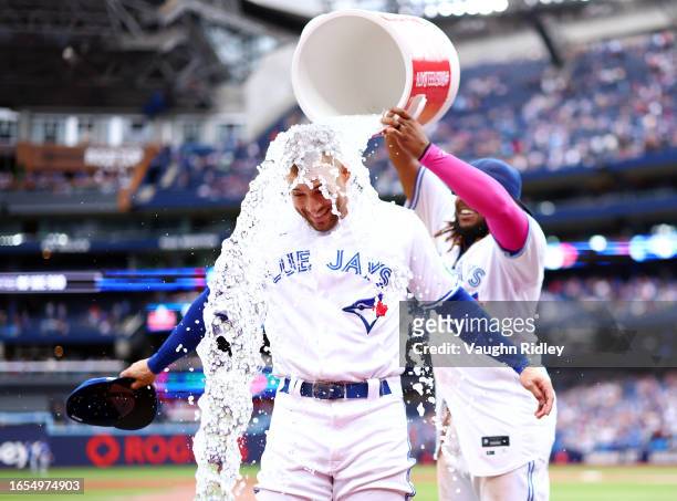 George Springer of the Toronto Blue Jays is doused with water by Vladimir Guerrero Jr. #27 following a win against the Kansas City Royals at Rogers...