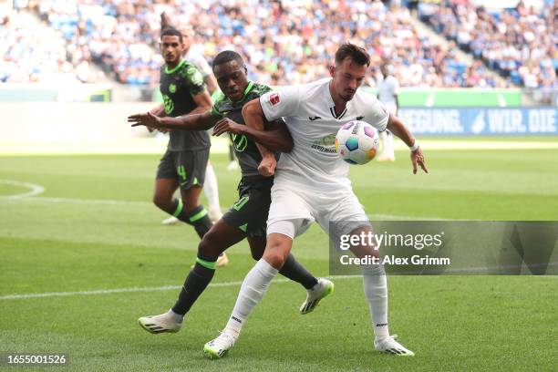 Ridle Baku of VfL Wolfsburg is challenged by Jacob Bruun Larsen of TSG 1899 Hoffenheim during the Bundesliga match between TSG Hoffenheim and VfL...