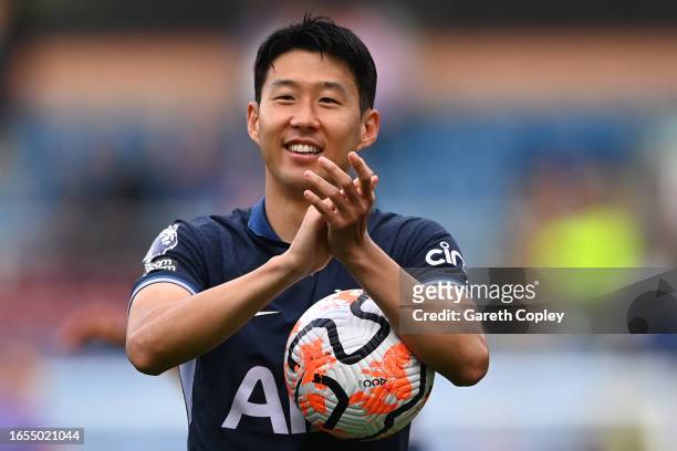 Heung-Min Son of Tottenham Hotspur applauds the fans as he carries the matchball after scoring a hat-trick after the Premier League match between...